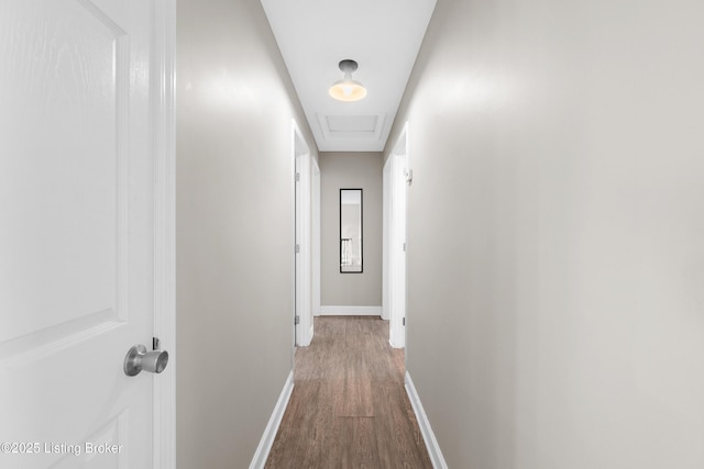 hallway featuring baseboards and dark wood-style flooring