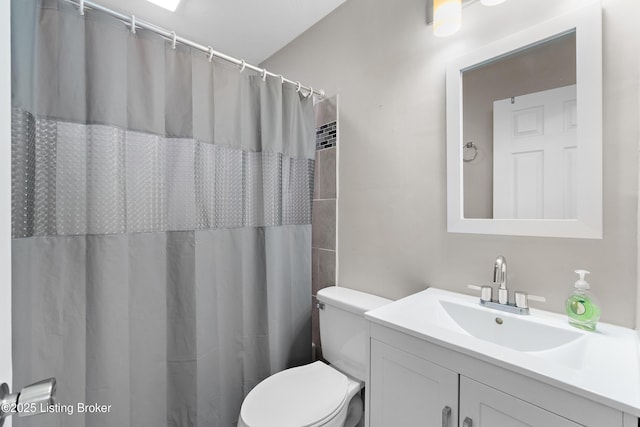 full bath with a shower with curtain, vanity, and toilet