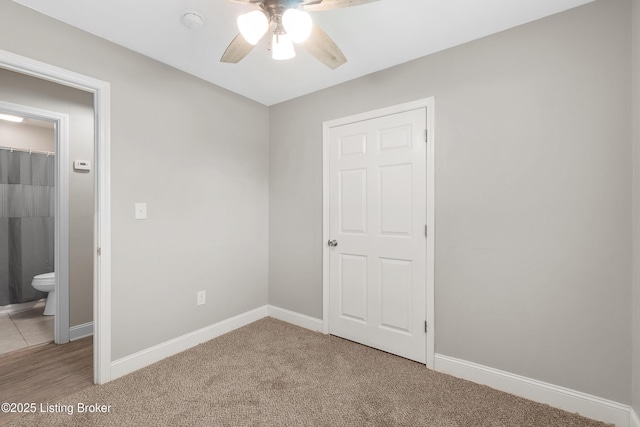 unfurnished bedroom featuring light colored carpet, ceiling fan, and baseboards
