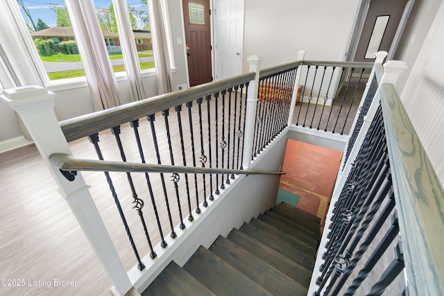 stairway with baseboards and wood finished floors