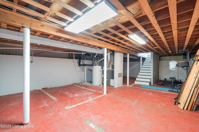 unfinished below grade area featuring heating unit, stairs, and gas water heater