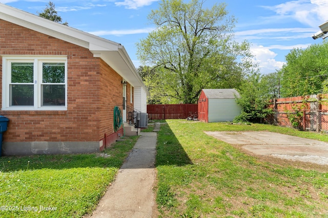 view of yard with central AC unit, a patio area, a shed, a fenced backyard, and an outbuilding