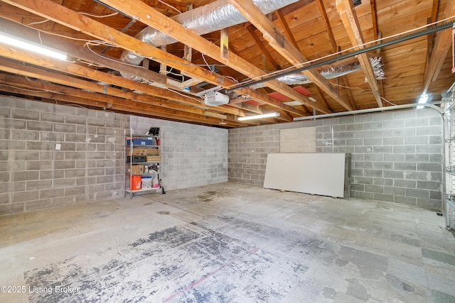 unfinished basement featuring concrete block wall