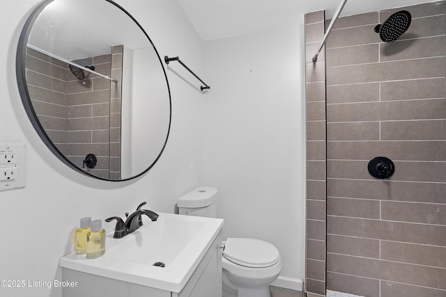full bathroom featuring a tile shower, toilet, and vanity