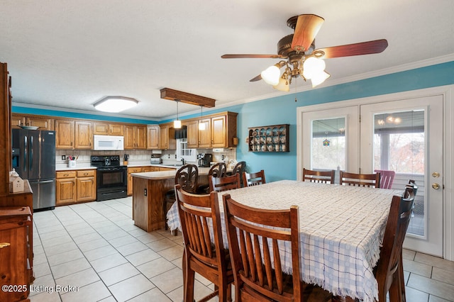 dining area featuring crown molding, a ceiling fan, and light tile patterned flooring