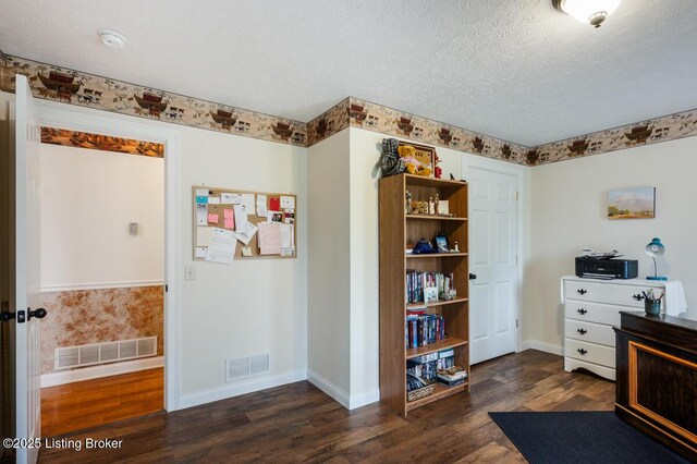 interior space featuring dark wood finished floors, baseboards, visible vents, and a textured ceiling