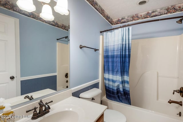 bathroom featuring toilet, vanity, and shower / bathtub combination with curtain