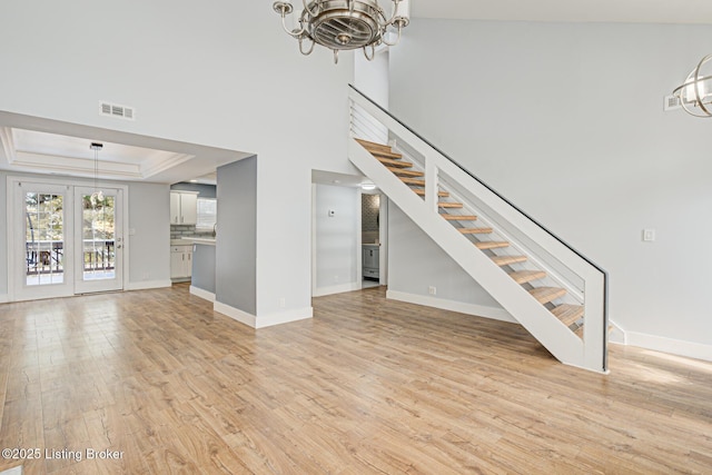 9003 Holly Village Ct, Lyndon, KY 40242 - unfurnished living room with visible vents, baseboards, a chandelier, light wood-style flooring, and stairs