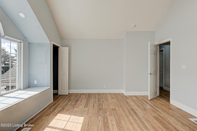 9003 Holly Village Ct, Lyndon, KY 40242 - unfurnished bedroom featuring baseboards, lofted ceiling, and light wood-style flooring