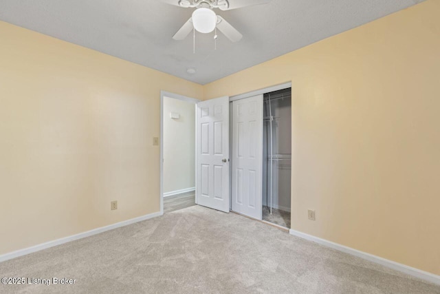 unfurnished bedroom featuring baseboards, a ceiling fan, carpet floors, and a closet