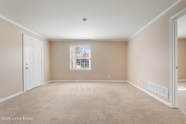 carpeted spare room featuring baseboards, visible vents, and ornamental molding