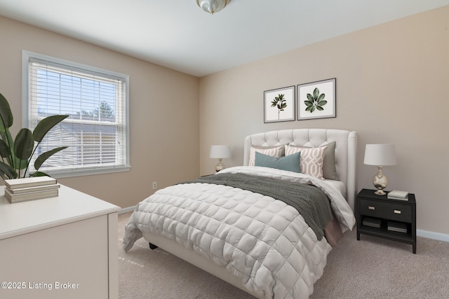 bedroom with light carpet and baseboards