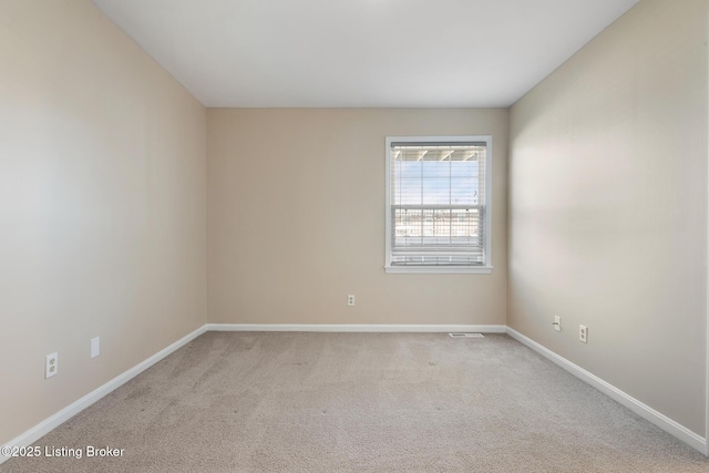 empty room featuring baseboards and carpet flooring