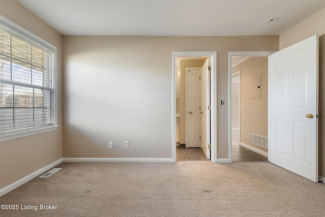 unfurnished bedroom featuring baseboards, visible vents, and carpet floors
