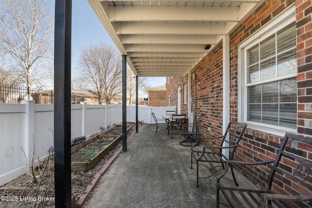 view of patio / terrace with a fenced backyard, a vegetable garden, and outdoor dining area
