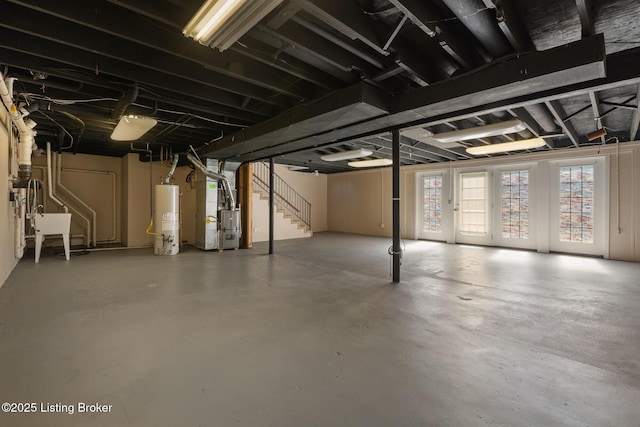 below grade area with stairway, heating unit, gas water heater, and a sink