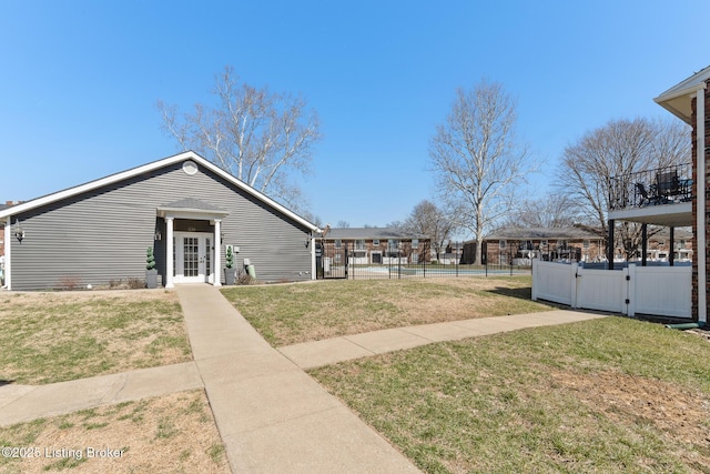 exterior space featuring a gate, fence, and a lawn