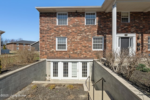 rear view of property with brick siding and french doors