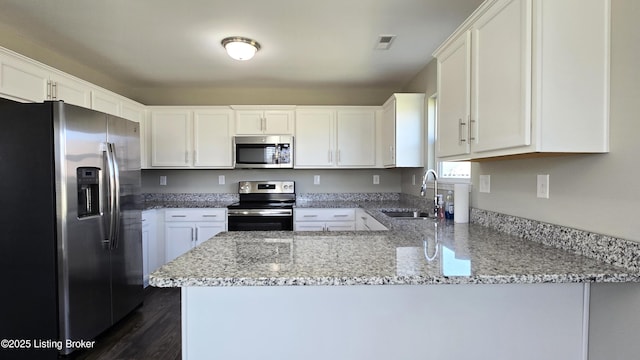 10916 Pheasant Hill Cir, Louisville, KY 40229 - kitchen featuring white cabinets, a peninsula, a sink, light stone counters, and appliances with stainless steel finishes