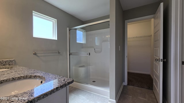 10916 Pheasant Hill Cir, Louisville, KY 40229 - bathroom featuring a walk in closet, baseboards, vanity, and a stall shower