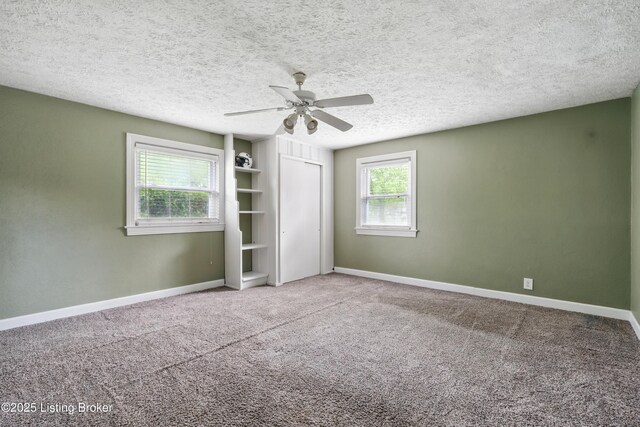 unfurnished bedroom with baseboards, a ceiling fan, carpet floors, and a closet