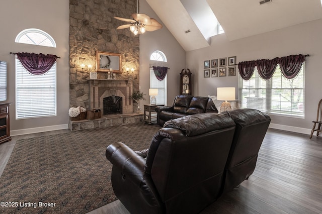living room with a fireplace, high vaulted ceiling, a ceiling fan, baseboards, and wood finished floors