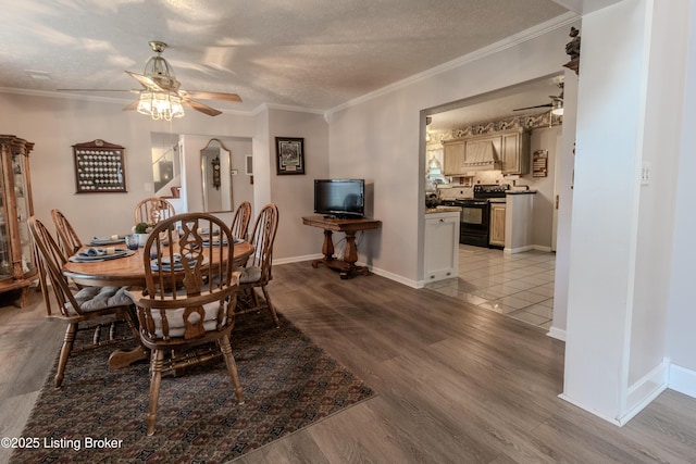 dining space with ornamental molding, a ceiling fan, and light wood-style flooring