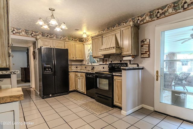 kitchen with an inviting chandelier, light tile patterned floors, black appliances, backsplash, and premium range hood