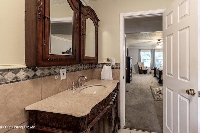 bathroom with crown molding, ceiling fan, a wainscoted wall, tile walls, and vanity