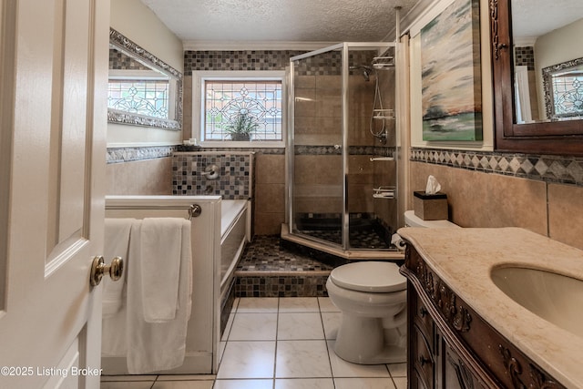 bathroom with a textured ceiling, a shower stall, toilet, tile walls, and tile patterned flooring
