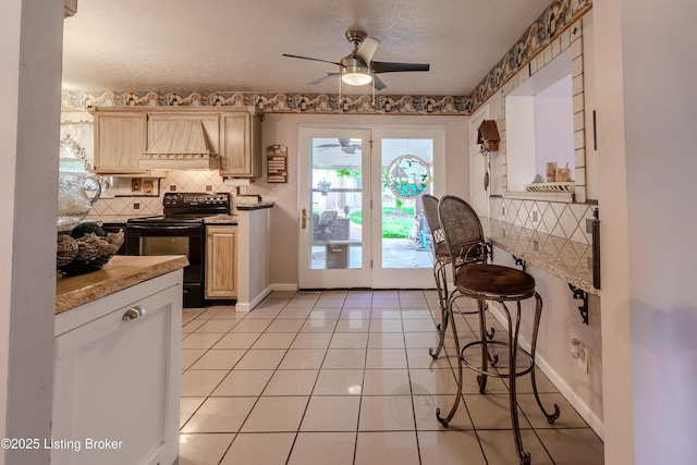 kitchen featuring tasteful backsplash, custom range hood, black electric range oven, baseboards, and a ceiling fan