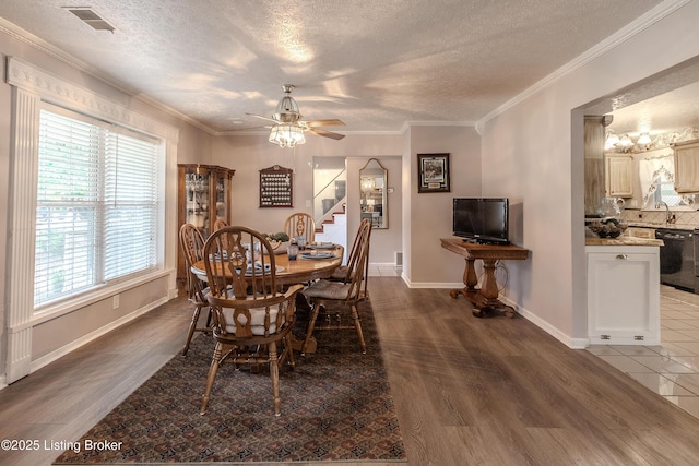 dining space featuring a textured ceiling, wood finished floors, ceiling fan, and stairway