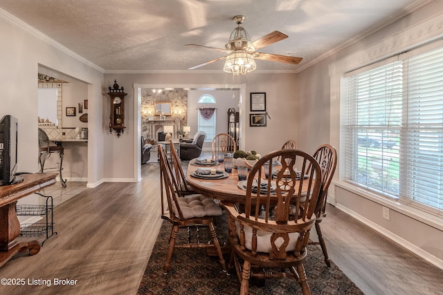 dining area with baseboards, wood finished floors, a ceiling fan, and ornamental molding