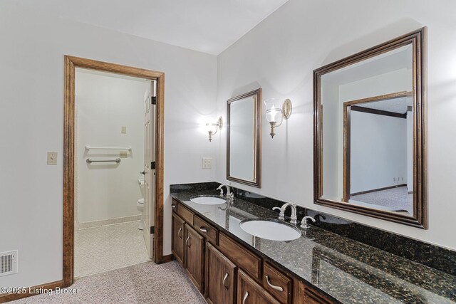 full bath with double vanity, visible vents, toilet, and a sink