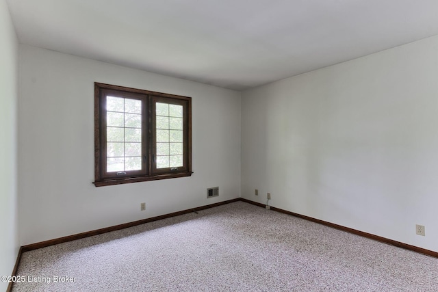 carpeted empty room featuring visible vents and baseboards