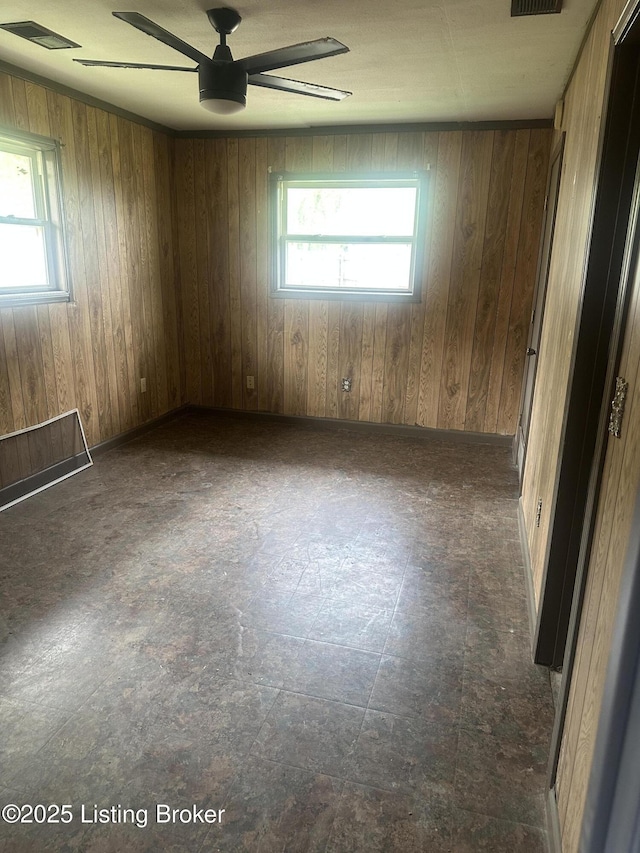 510 S Kentucky St, Irvington, KY 40146 - unfurnished room with wooden walls, a healthy amount of sunlight, a ceiling fan, and visible vents