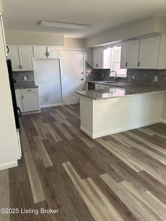 510 S Kentucky St, Irvington, KY 40146 - kitchen featuring tasteful backsplash, dark stone countertops, a sink, white cabinets, and a peninsula