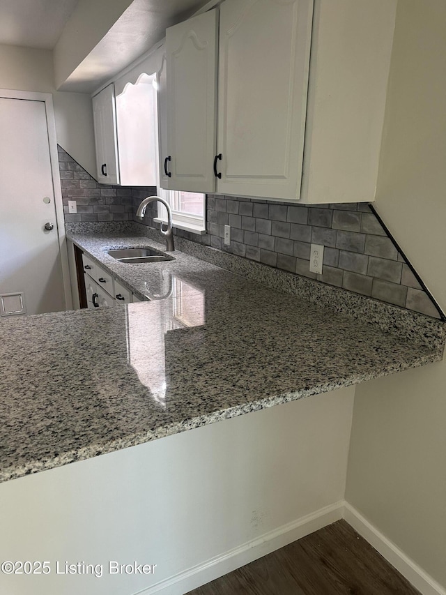 510 S Kentucky St, Irvington, KY 40146 - kitchen featuring white cabinets, light stone counters, a sink, dark wood-type flooring, and decorative backsplash