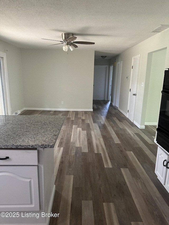 510 S Kentucky St, Irvington, KY 40146 - unfurnished living room featuring a ceiling fan, visible vents, a textured ceiling, and dark wood finished floors