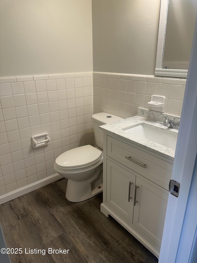510 S Kentucky St, Irvington, KY 40146 - half bathroom featuring a wainscoted wall, wood finished floors, toilet, vanity, and tile walls