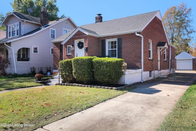 view of front of home with a shingled roof, a chimney, brick siding, and a front yard