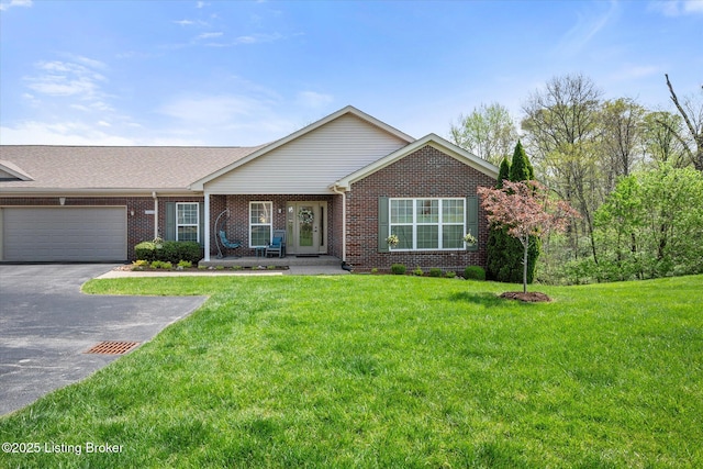 single story home featuring an attached garage, brick siding, driveway, and a front lawn