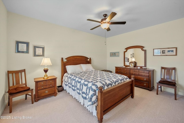 bedroom with light colored carpet, baseboards, and a ceiling fan