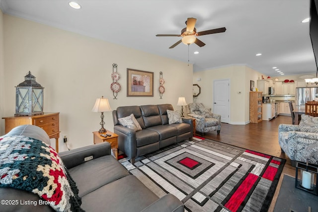 living area featuring baseboards, recessed lighting, ceiling fan, dark wood-type flooring, and ornamental molding