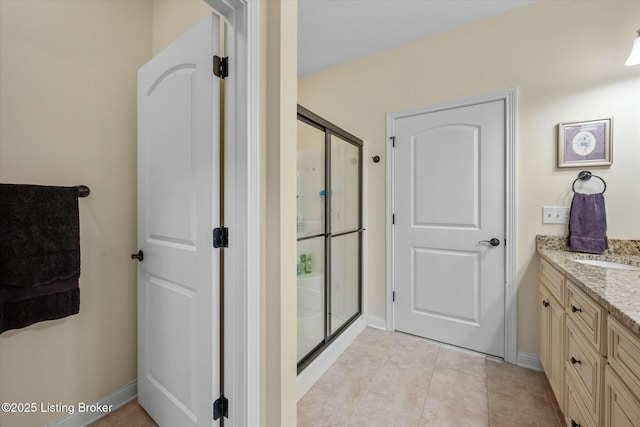 full bathroom featuring tile patterned flooring, baseboards, vanity, and a stall shower