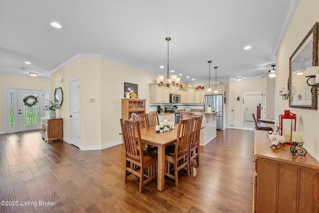 dining space featuring crown molding, ceiling fan with notable chandelier, dark wood finished floors, baseboards, and recessed lighting