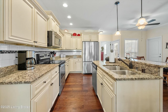 kitchen with stainless steel appliances, dark wood-style floors, a sink, and cream cabinets