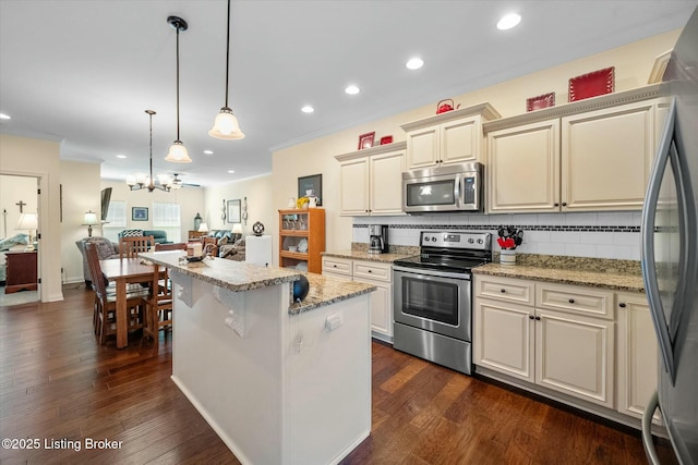 kitchen featuring tasteful backsplash, appliances with stainless steel finishes, open floor plan, and ornamental molding