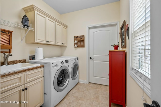 clothes washing area with cabinet space, independent washer and dryer, light tile patterned flooring, and a sink