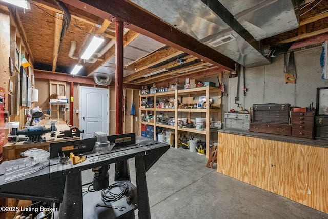 unfinished basement with a workshop area and visible vents